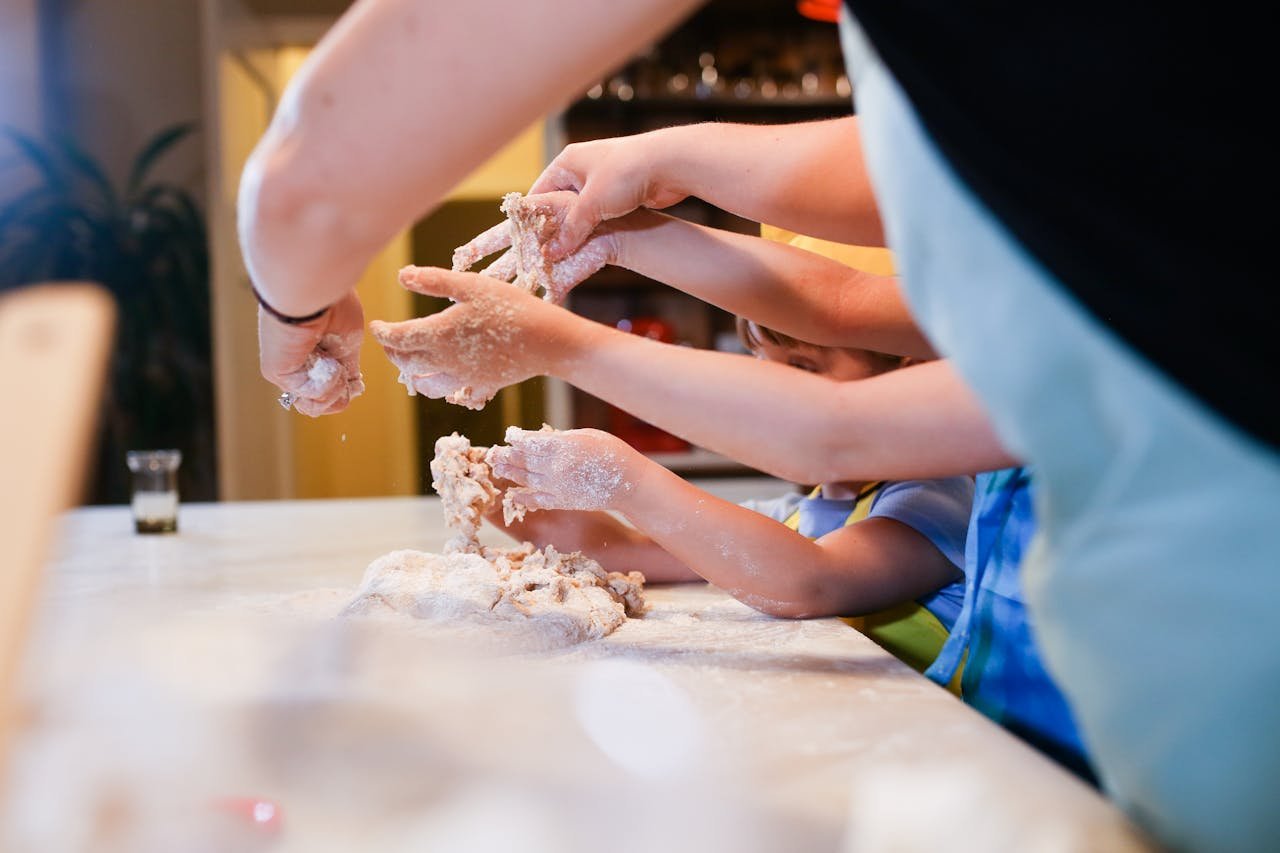 Engaging family cooking session with children making dough together.