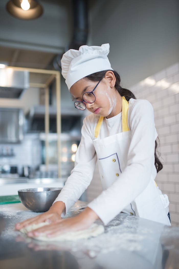 Child chef kneading dough in a contemporary kitchen, Portugal.